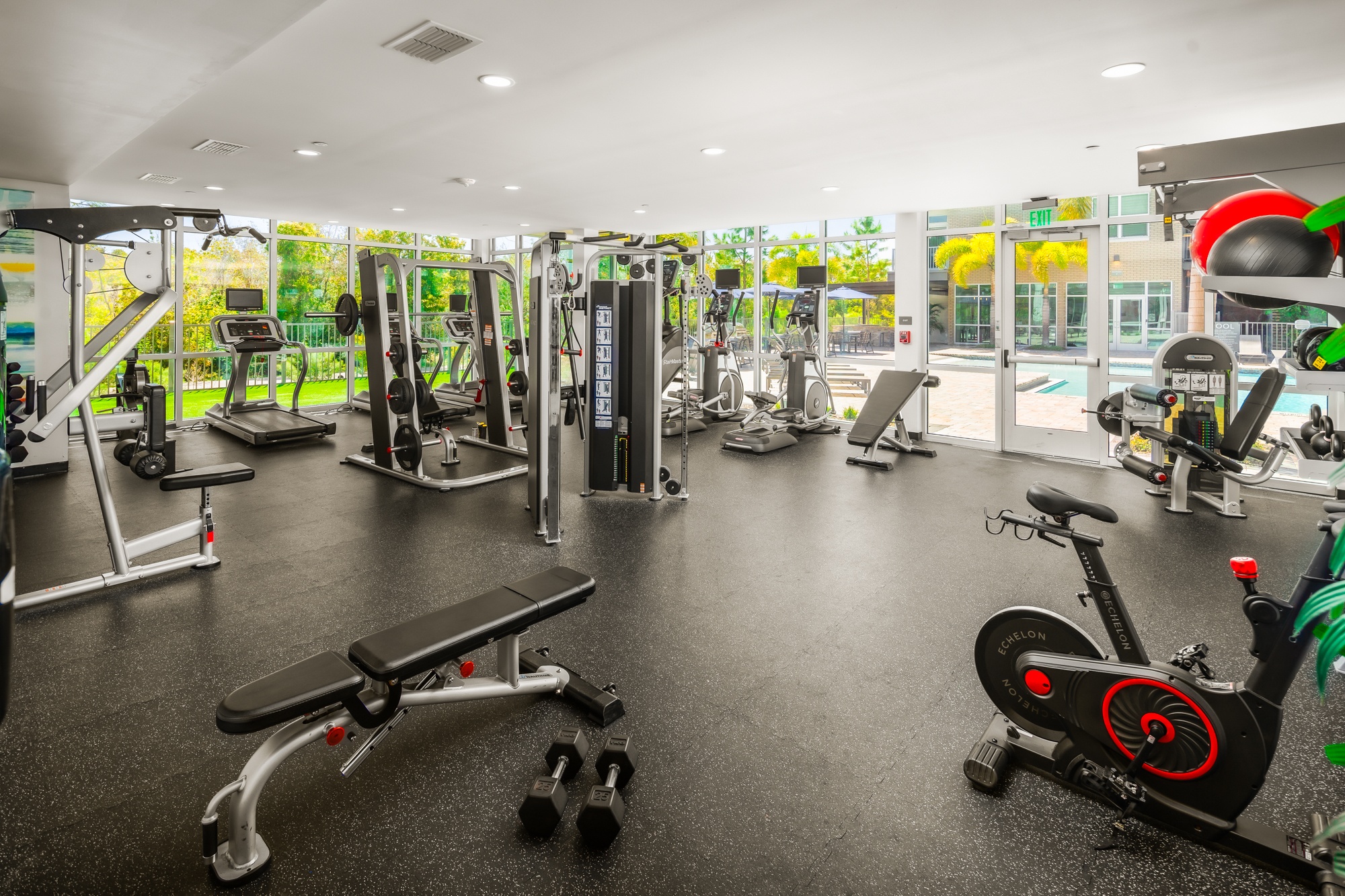 A gym with a variety of equipment including weights, treadmills, and exercise bikes.
